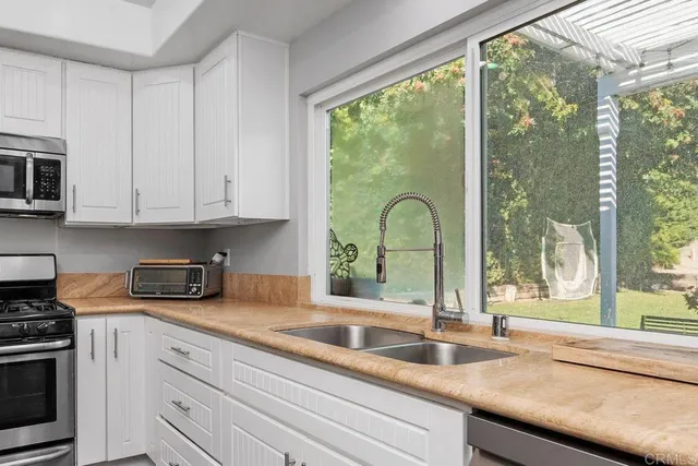 a kitchen with granite countertop a stove a sink and a wooden floor