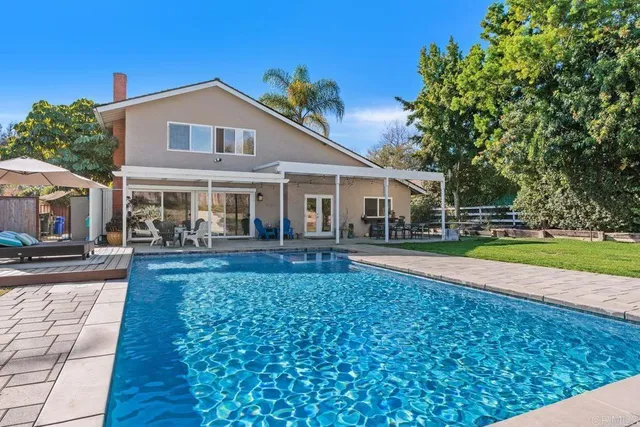 a view of a house with a yard patio and swimming pool