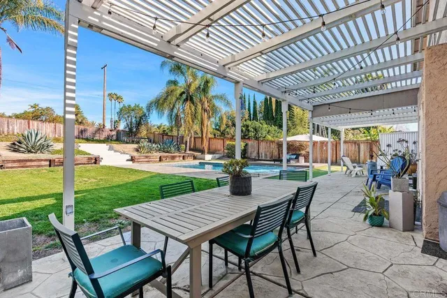 a view of a patio with table and chairs and a barbeque