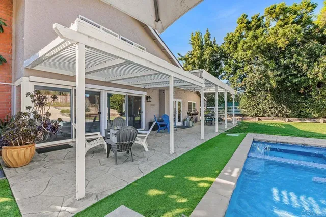 a view of a house with backyard porch and sitting area