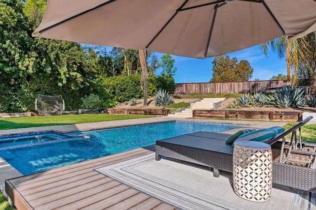 a view of a patio with a table and chairs under an umbrella