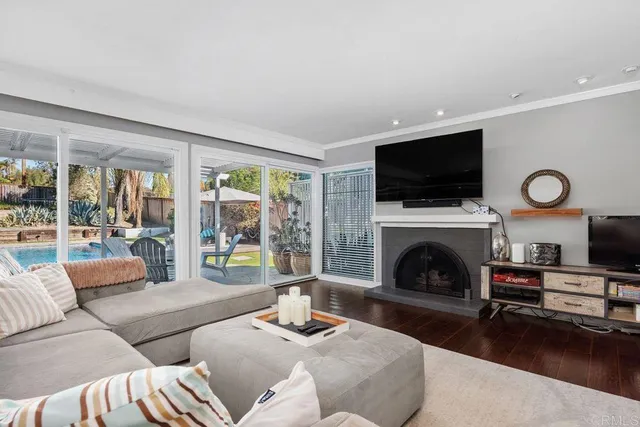 a living room with furniture a fireplace and a flat screen tv