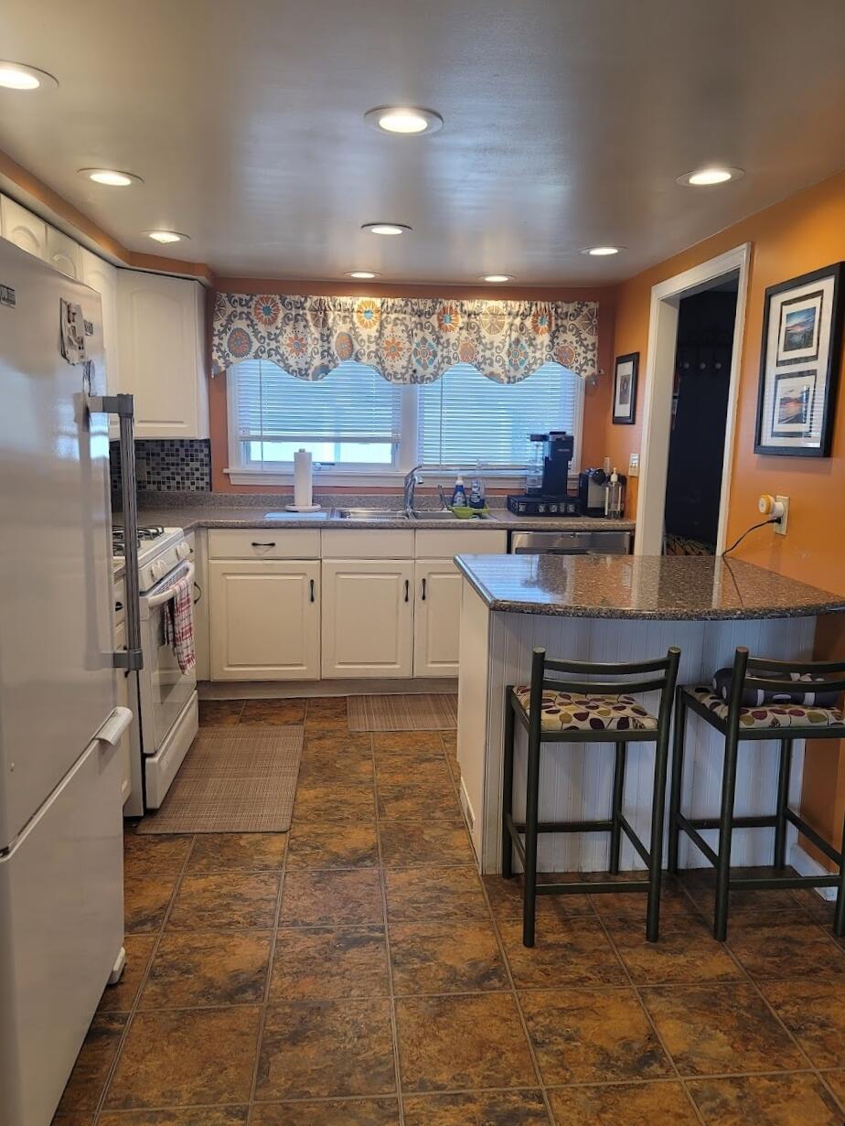 95 Spring Street Hyannis, MA 02601 - Photo 10 of 38 a kitchen with stainless steel appliances granite countertop a table chairs sink and cabinets
