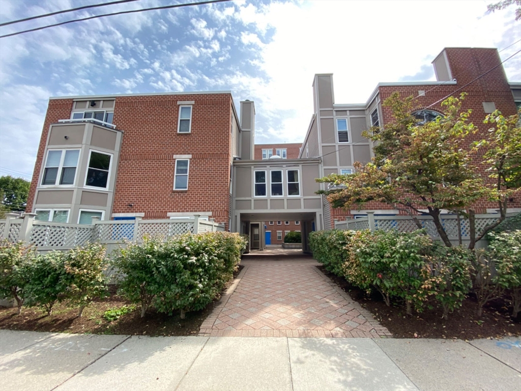 a front view of a residential apartment building with a yard