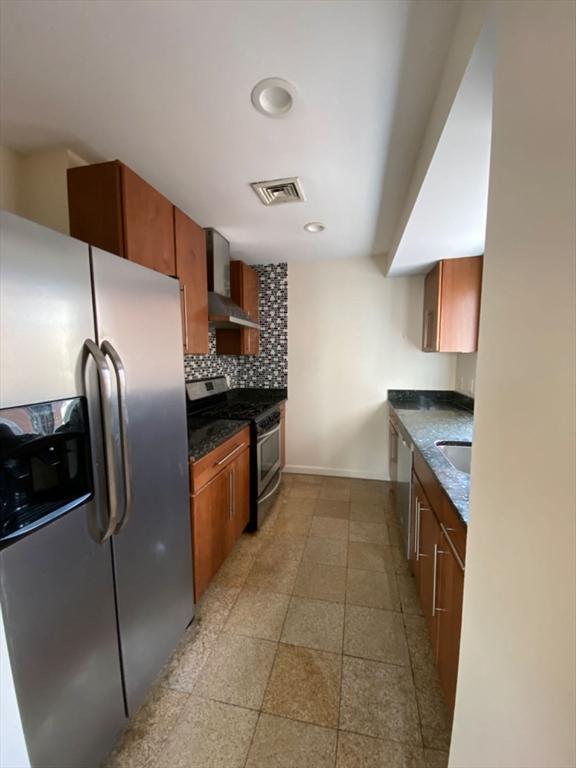 22 Chestnut Street, Unit 22 Cambridge, MA 02139 - Photo 4 of 18 a kitchen with stainless steel appliances granite countertop a sink a stove and a refrigerator