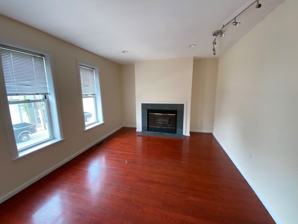 22 Chestnut Street, Unit 22 Cambridge, MA 02139 - Photo 8 of 18 a view of an empty room with wooden floor fireplace and a window