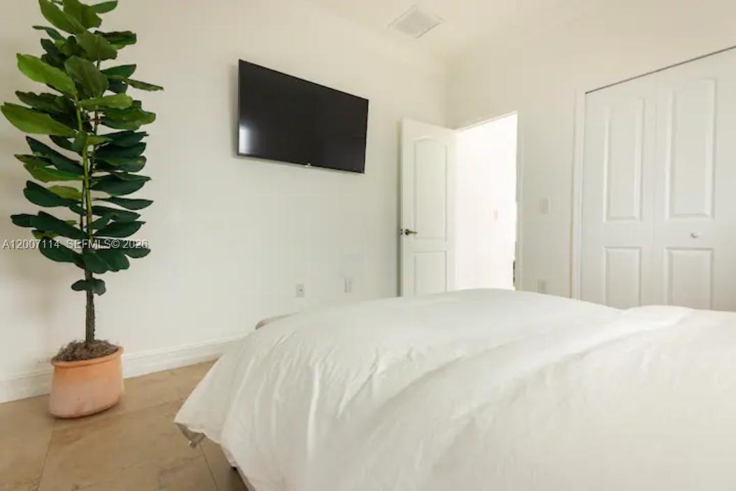 15566 Southwest 13th Terrace Miami, FL 33194 - Photo 16 of 27 a bedroom with a bed and a potted plant