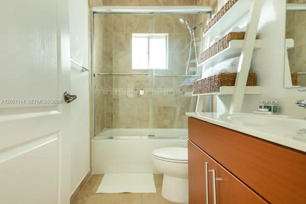 15566 Southwest 13th Terrace Miami, FL 33194 - Photo 19 of 27 a bathroom with a granite countertop sink a toilet and shower
