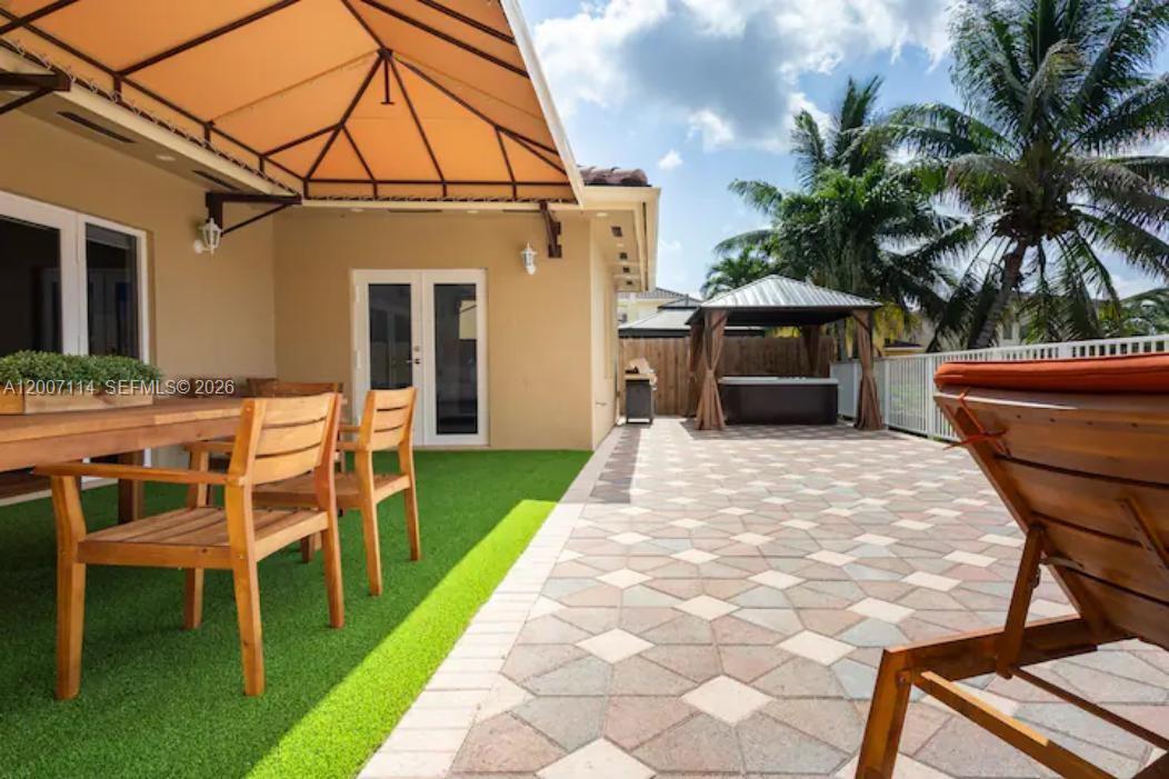 15566 Southwest 13th Terrace Miami, FL 33194 - Photo 21 of 27 a view of a patio with table and chairs with wooden fence