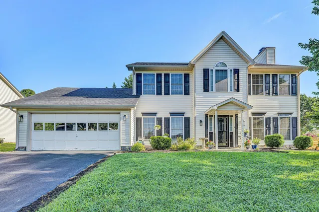 a front view of a house with a garden and yard