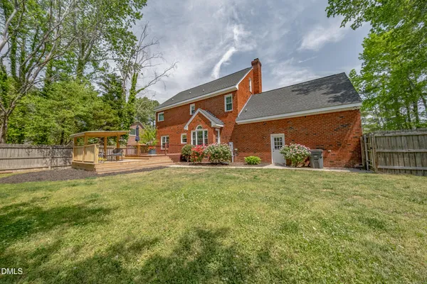 a view of a house with a small yard and large tree