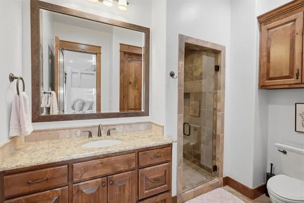 a bathroom with a sink a toilet and shower
