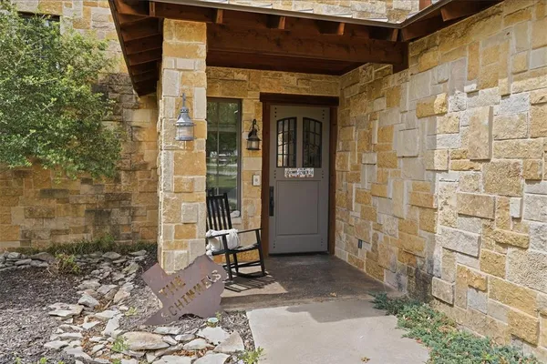 a view of a door and chair and table in front of house