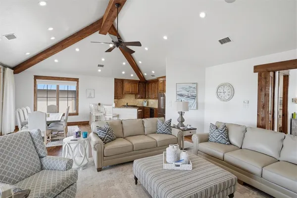 a living room with furniture kitchen view and a chandelier