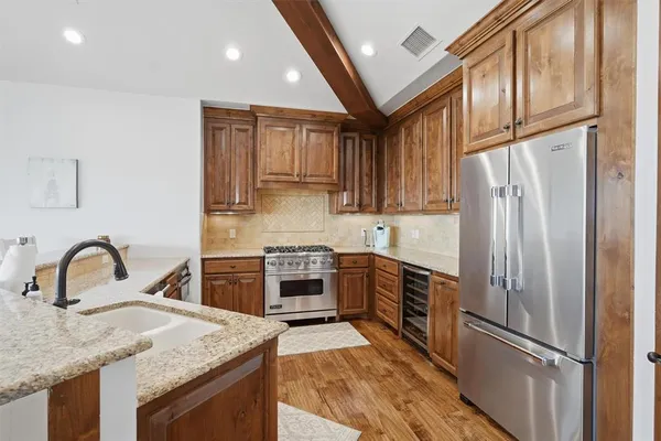 a kitchen with granite countertop a refrigerator stove and sink