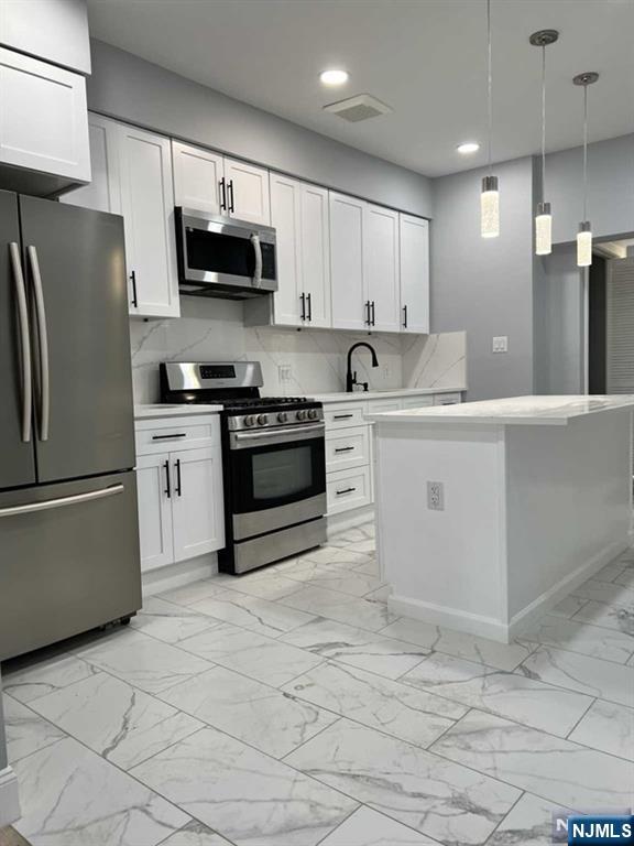 a kitchen with stainless steel appliances granite countertop a refrigerator sink stove microwave and cabinets