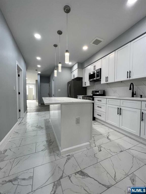 326 70th Street, Unit 2 Guttenberg, NJ 07093 - Photo 5 of 15 a kitchen with stainless steel appliances kitchen island granite countertop a sink and cabinets