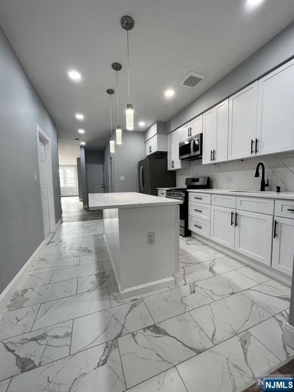 326 70th Street, Unit 2 Guttenberg, NJ 07093 - Photo 6 of 15 a kitchen with stainless steel appliances kitchen island granite countertop a sink and cabinets