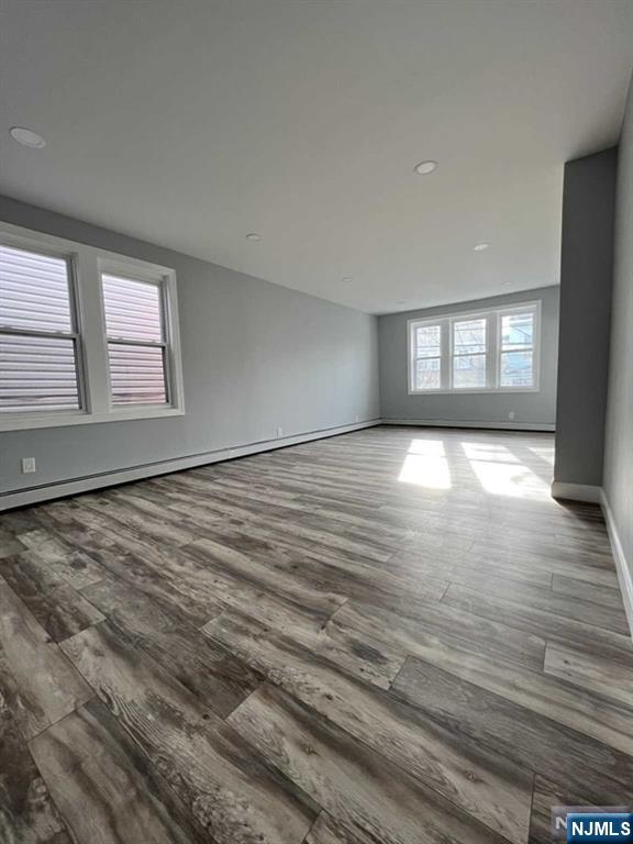326 70th Street, Unit 2 Guttenberg, NJ 07093 - Photo 9 of 15 an empty room with wooden floor and windows