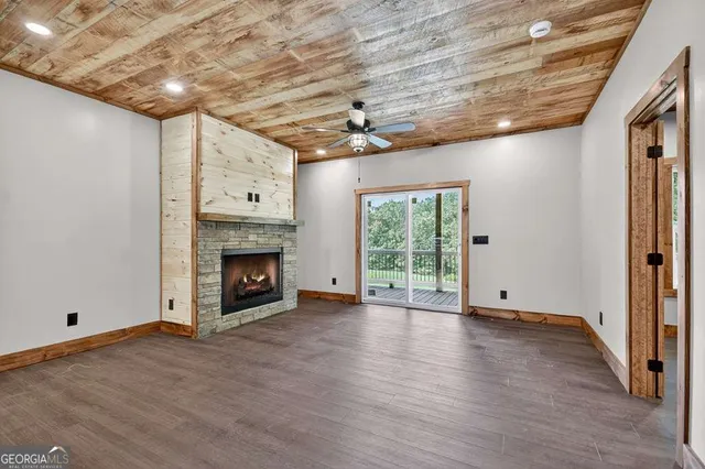 a view of empty room with wooden floor and fireplace