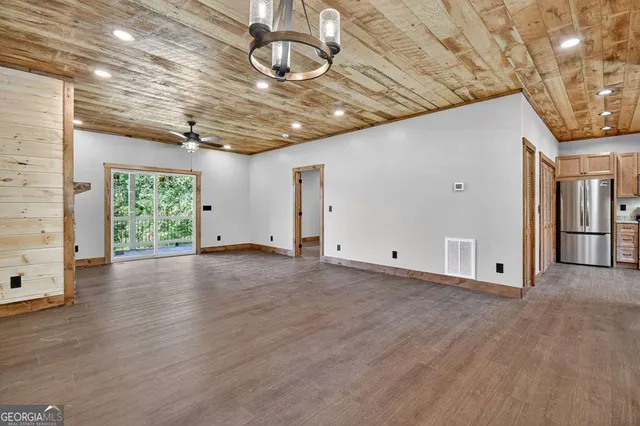 a view of empty room with wooden floor and window