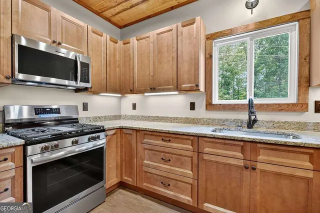 a kitchen with granite countertop a sink and white cabinets