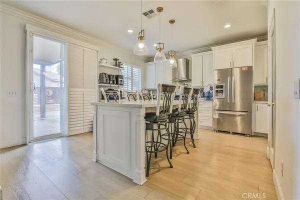 a kitchen with stainless steel appliances kitchen island granite countertop a refrigerator and a stove top oven