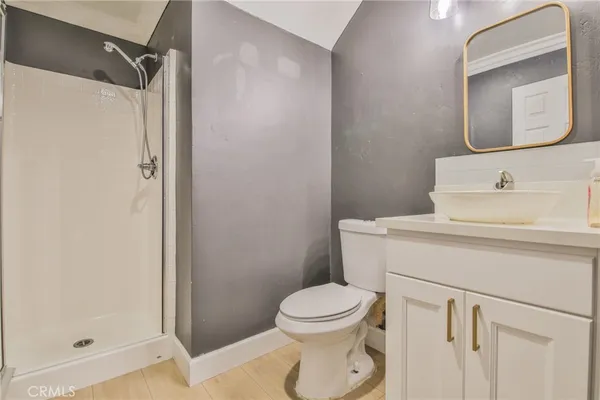 a bathroom with a toilet sink vanity and shower