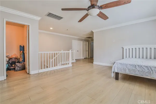 a spacious bedroom with a bed and a chandelier