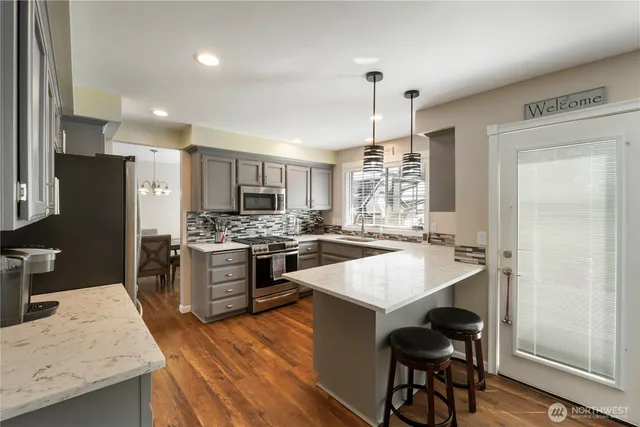 a kitchen with a island a sink stainless steel appliances and cabinets