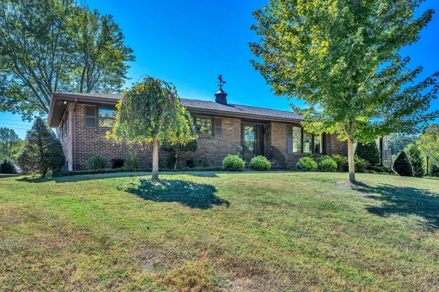 a view of a house with yard and tree s