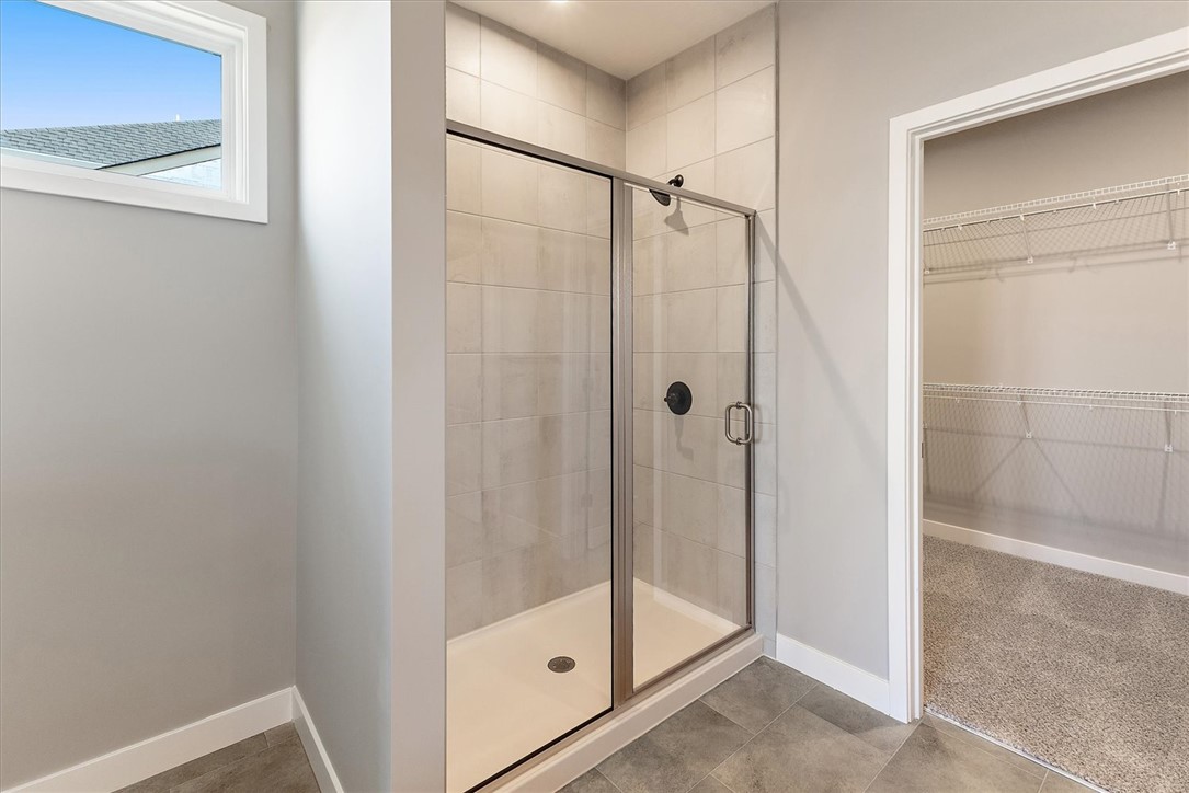 407 South Landon Lane Springfield, OH 45502 - Photo 13 of 30 A well-appointed primary bathroom showcases a glass-enclosed shower and a spacious walk-in closet.