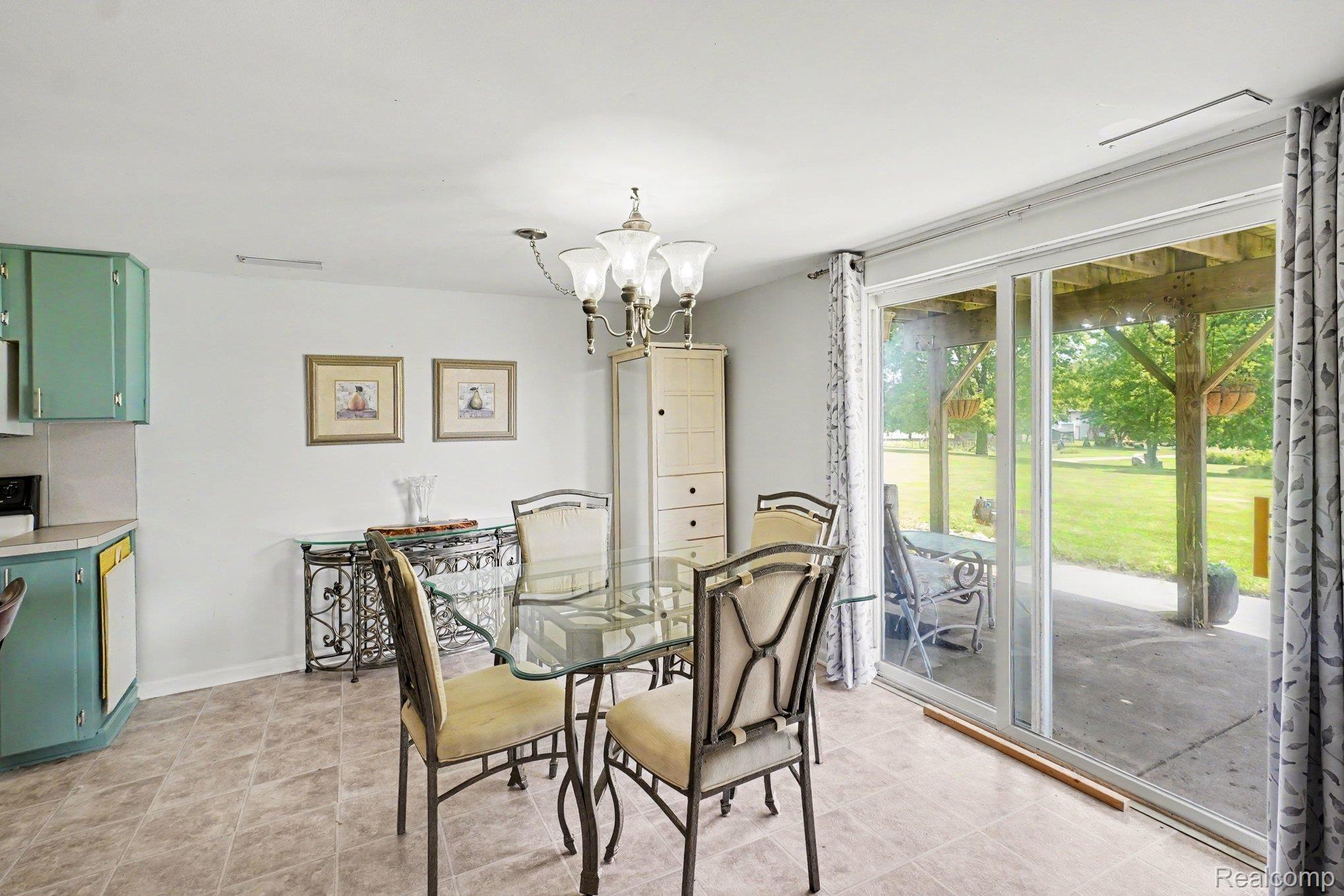 4848 Columbiaville Road Columbiaville, MI 48421 - Photo 21 of 35 Dining area featuring tile-finish flooring and a brass chandelier
