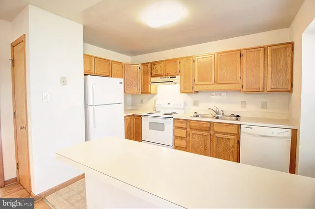 a kitchen with a refrigerator sink and cabinets