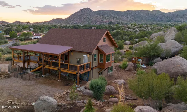 an aerial view of a house with a mountain in the background