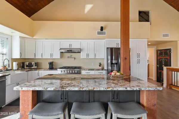 a kitchen with stainless steel appliances granite countertop a sink stove and refrigerator
