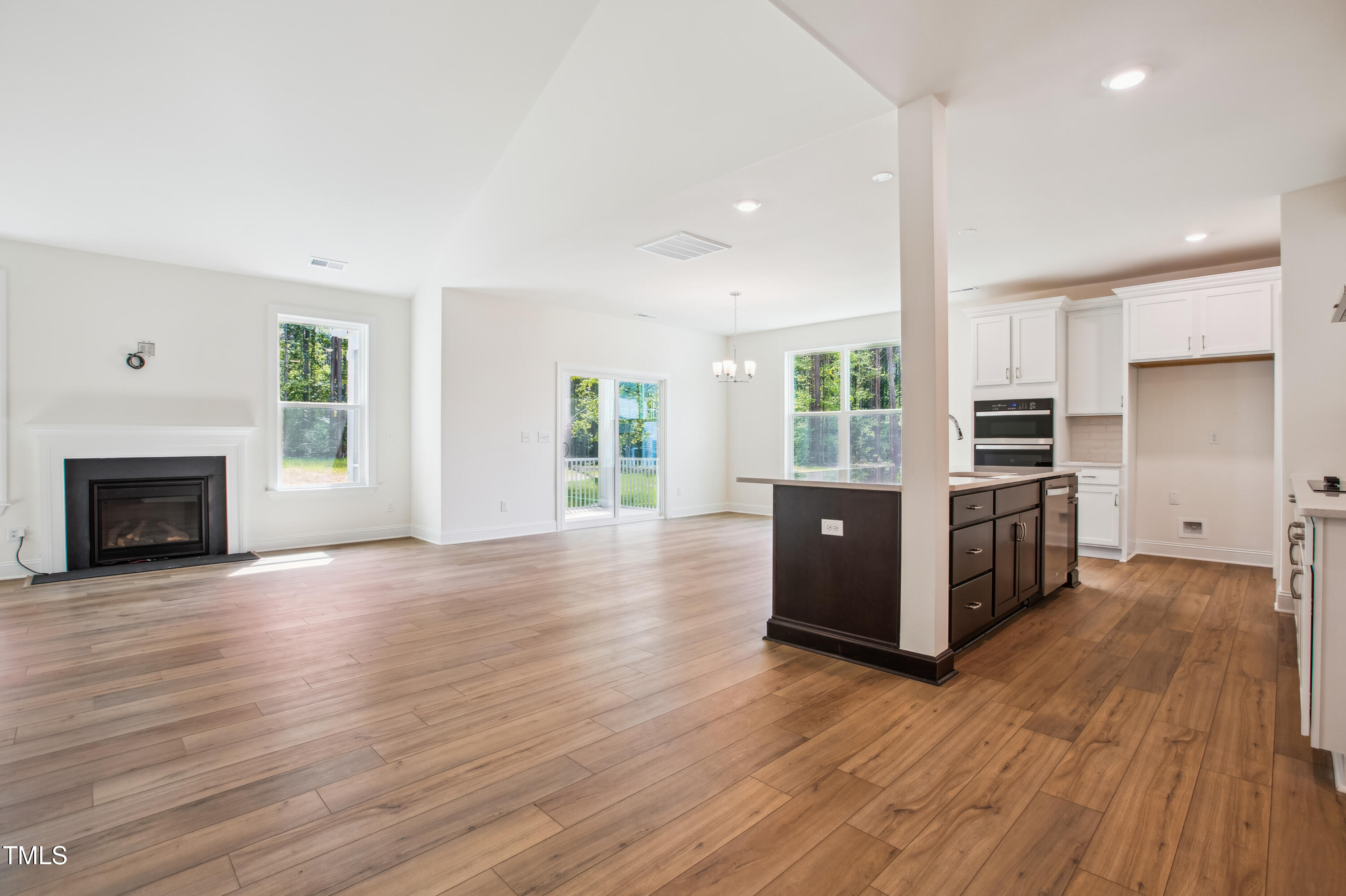 73 Artic Circle Garner, NC 27529 - Photo 9 of 39 an empty room with wooden floor fireplace and windows