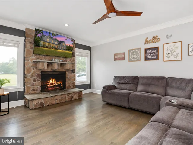 a living room with furniture a fireplace and a flat screen tv