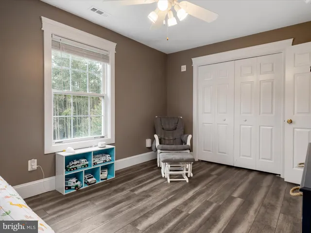 a living room with furniture a wooden floor and a large window