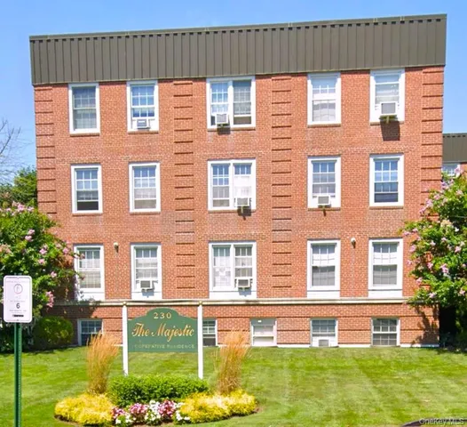 front view of a brick house with a yard