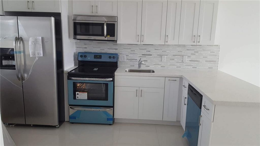 3150 North Course Lane, Unit 607 Pompano Beach, FL 33069 - Photo 4 of 16 a kitchen with a stove and a refrigerator