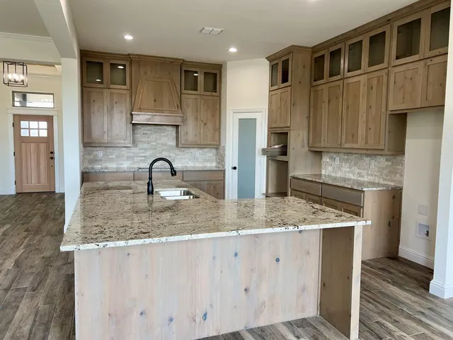 a kitchen with stainless steel appliances granite countertop a sink stove and cabinets