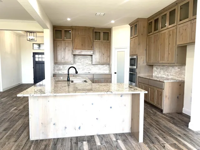 a kitchen with stainless steel appliances granite countertop a sink a stove and a refrigerator