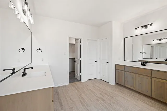 a spacious bathroom with a double vanity sink a mirror and a shower