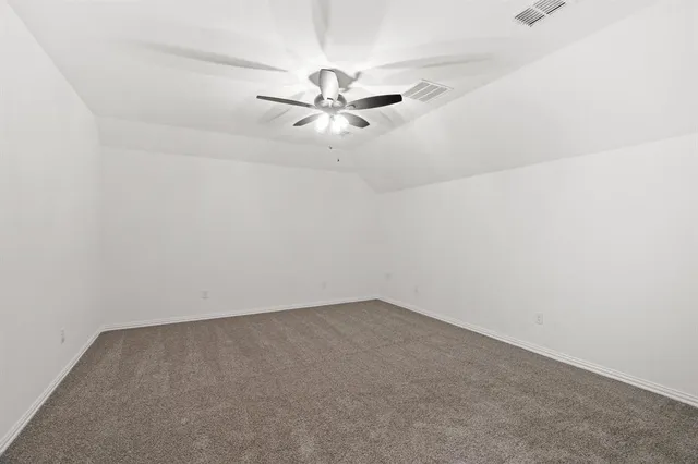 an empty room with a window and ceiling fan