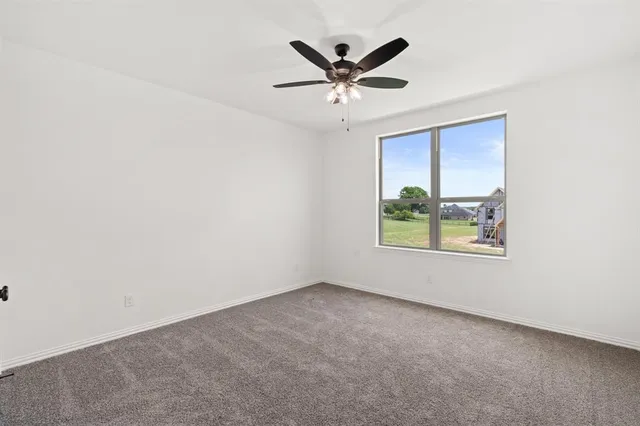 an empty room with window and ceiling fan