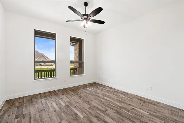 an empty room with a window and a ceiling fan