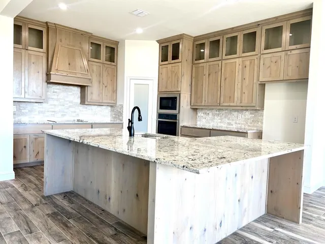 a kitchen with stainless steel appliances granite countertop a sink stove and cabinets