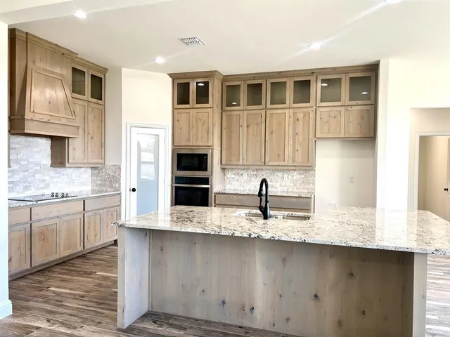 a kitchen with stainless steel appliances granite countertop a sink and a stove