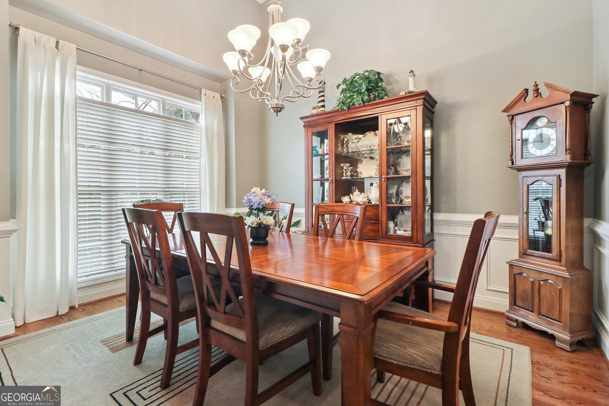3792 Falls Trail Winston, GA 30187 - Photo 15 of 24 a dining room with wooden floor a chandelier a wooden table and chairs